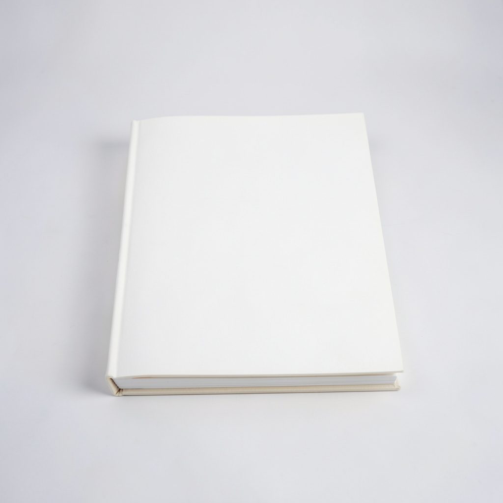 A composition book with handwritten notes, evoking planning and creativity, on a warm wooden desk